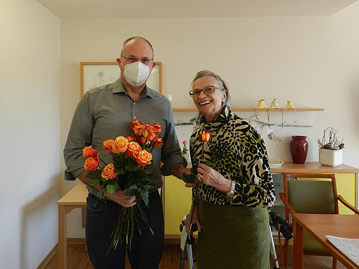 Heimleiter Hans-Joachim Siebenborn übergibt zum Internationen Weltfrauentag einer Bewohnerin eine Rose